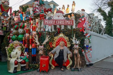 BrooKLYN, New York - 14 Aralık 2023: Lucy Spata, Brooklyn 'in Dyker Heights semtindeki Noel evi dekorasyonunun önünde. 1986 'da Dyker Heights' taki dekorasyon trendine öncülük etti.