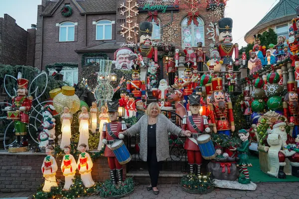 BrooKLYN, New York - 14 Aralık 2023: Lucy Spata, Brooklyn 'in Dyker Heights semtindeki Noel evi dekorasyonunun önünde. 1986 'da Dyker Heights' taki dekorasyon trendine öncülük etti.