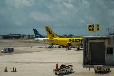 WEST PALM BEACH, FLORIDA - MAY 31, 2021: Spirit Airlines and JetBlue planes on tarmac at Palm Beach International Airport, Florida. Spirit Airlines is the leading Ultra Low Cost Carrier in the USA, the Caribbean and Latin America clipart