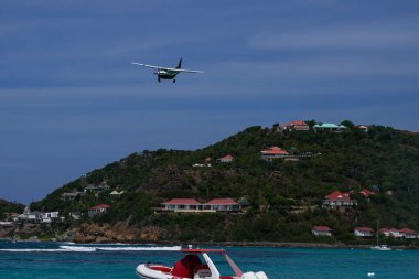 St. Barts, FRENCH Batı INDIES - 18 Nisan 2024: Winair De Havilland Kanada DHC-6-300 Twin Otter uçağı Remy de Haenen Havalimanı 'na inmek üzere inmiştir. 2,133 feet yüksekliğindeki pisti dünyanın en kısa pistlerinden biridir..
