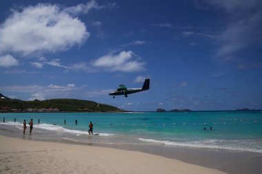St. Barts, FRENCH Batı INDIES - 18 Nisan 2024: Winair De Havilland Kanada DHC-6-300 Twin Otter uçağı Remy de Haenen Havalimanı 'na inmek üzere inmiştir. 2,133 feet yüksekliğindeki pisti dünyanın en kısa pistlerinden biridir..