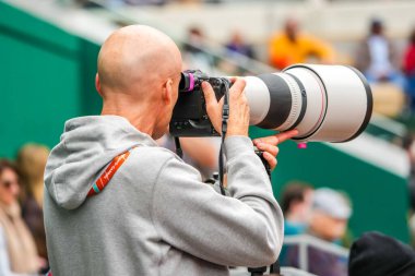 PARIS, FRANCE - JUNE 2, 2024: Professional sport photographer during tennis match at 2024 Roland Garros in Paris, France clipart