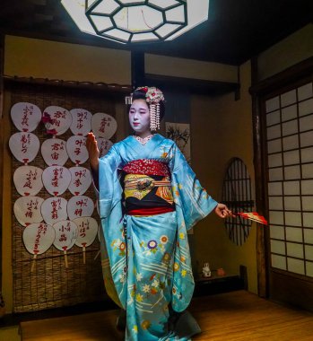 KYOTO, JAPAN - OCTOBER 8, 2024: Maiko apprentice showing Japanese traditional dance. Maiko is an apprentice geisha. Maikos performing songs, playing shamisen or instruments for visitors on ozashiki. clipart