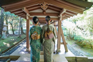 KYOTO, JAPONYA - 6 Ekim 2024: Kyoto, Japonya 'daki Ryoanji Tapınağı' nda geleneksel kimonolu genç Japon kadınlar