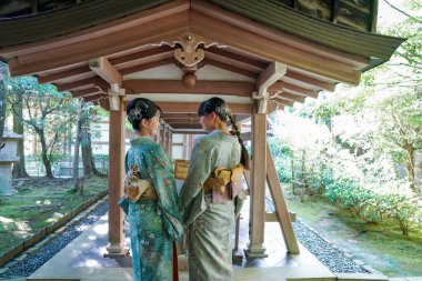 KYOTO, JAPONYA - 6 Ekim 2024: Kyoto, Japonya 'daki Ryoanji Tapınağı' nda geleneksel kimonolu genç Japon kadınlar
