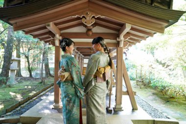 KYOTO, JAPONYA - 6 Ekim 2024: Kyoto, Japonya 'daki Ryoanji Tapınağı' nda geleneksel kimonolu genç Japon kadınlar
