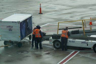 NEW YORK - 31 Mayıs 2021: JetBlue bagaj taşıyıcıları New York 'taki John F. Kennedy Uluslararası Havaalanı' nda piste bagaj yükleme