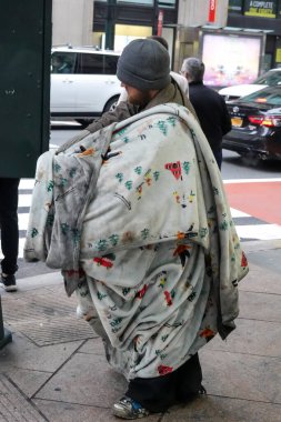 NEW YORK - DECEMBER 10, 2024: Homeless man in Midtown Manhattan clipart