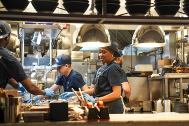 NEW YORK - NOVEMBER 8, 2024: Cooks in the kitchen of Tonchin Tokyo-based ramen chain restaurant in Midtown Manhattan, New York clipart