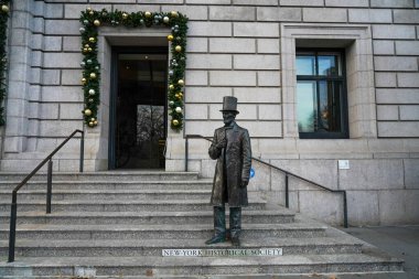 NEW YORK - DECEMBER 4, 2021: Statue of Abraham Lincoln, 16th President of the United States, on the steps of the New York Historical Society building, at 170 Central Park West.  clipart