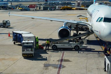 NEW YORK - 24 Mart 2024: JetBlue bagaj idarecisi New York 'taki John F. Kennedy Uluslararası Havaalanı' ndaki piste bagaj yüklüyor