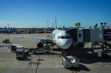 NEW YORK - 24 Mart 2024: JetBlue bagaj idarecisi New York 'taki John F. Kennedy Uluslararası Havaalanı' ndaki piste bagaj yüklüyor