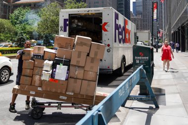 NEW YORK - 20 Haziran 2024: FedEx sürücüsü Manhattan şehir merkezinde paket dağıtıyor
