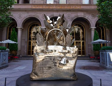 NEW YORK - 20 Haziran 2024: Roman Feral tarafından yapılmış dev, bronz bir Hermes Birkin çanta heykeli Manhattan şehir merkezindeki Lotte New York Palace Hotel 'in avlusunda sergileniyor..