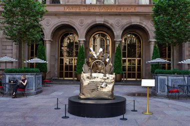 NEW YORK - 20 Haziran 2024: Roman Feral tarafından yapılmış dev, bronz bir Hermes Birkin çanta heykeli Manhattan şehir merkezindeki Lotte New York Palace Hotel 'in avlusunda sergileniyor..