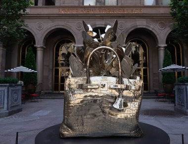 NEW YORK - 20 Haziran 2024: Roman Feral tarafından yapılmış dev, bronz bir Hermes Birkin çanta heykeli Manhattan şehir merkezindeki Lotte New York Palace Hotel 'in avlusunda sergileniyor..