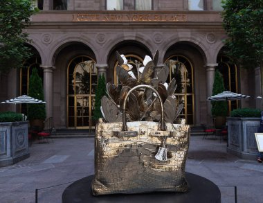 NEW YORK - 20 Haziran 2024: Roman Feral tarafından yapılmış dev, bronz bir Hermes Birkin çanta heykeli Manhattan şehir merkezindeki Lotte New York Palace Hotel 'in avlusunda sergileniyor..
