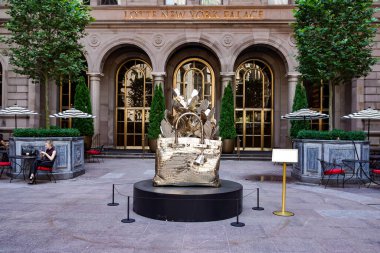 NEW YORK - 20 Haziran 2024: Roman Feral tarafından yapılmış dev, bronz bir Hermes Birkin çanta heykeli Manhattan şehir merkezindeki Lotte New York Palace Hotel 'in avlusunda sergileniyor..