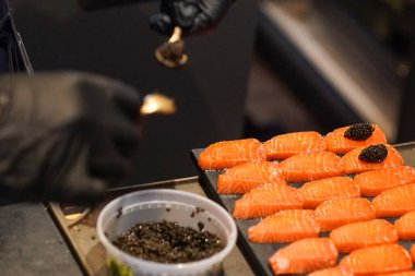 Şef Kore restoranında somon balığı ve havyar rulosu hazırlıyor.