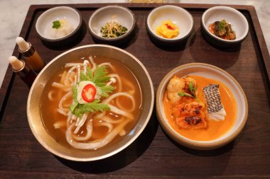Istakoz kalguksu, gochujang boullabaisse, kimchi ve sebze turşusu Kore restoranında servis edilir. Kalguksu ev yapımı, buğday unlu erişteli Kore eriştesidir.