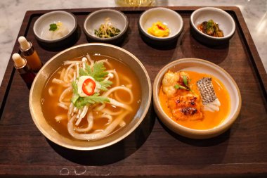 Istakoz kalguksu, gochujang boullabaisse, kimchi ve sebze turşusu Kore restoranında servis edilir. Kalguksu ev yapımı, buğday unlu erişteli Kore eriştesidir.
