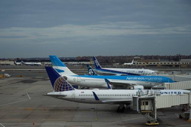 NEW YORK - 10 Aralık 2021: United Airlines, Aerolineas Argentinas, Alaska Airlines and All Nippon Airways (ANA) uçakları JFK Uluslararası Havalimanı Terminal 7 'nin kapısında park halindedir.