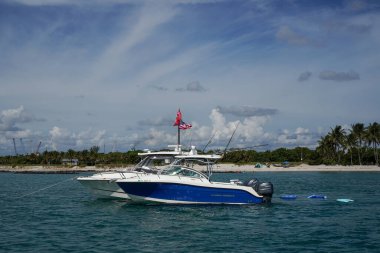 RIVIERA BEACH, FLORIDA - 10 Haziran 2024: Amerikan Bayrağı ve Trump 2024 Tanrı Amerika Özgürlük Bayrağı, Palm Beach, Florida, ABD 'deki Lake Worth körfezinin ağzında yer alan Peanut Adası önünde demirli