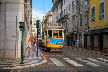 LISBON, PORTUGAL - 15 Eylül 2023: Rua Nova do Almada 'daki Lizbon Tramvayı, şehrin en ikonik tramvayı. Pirinç düğmeleri ve cilalanmış ahşap iç döşemeler gibi orijinal 1930 'lu yıllarda kullanılan klasik sarı tramvaylar.