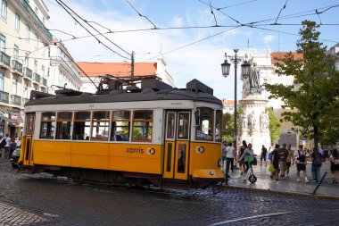 LISBON, PORTUGAL - 15 Eylül 2023: Tram 24 Lizbon, Portekiz 'deki Largo do Chiado' da durdu. Pirinç düğmeleri ve cilalanmış ahşap iç döşemeler gibi orijinal 1930 'lu yıllarda kullanılan klasik sarı tramvaylar.