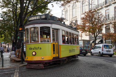 LISBON, PORTUGAL - 15 Eylül 2023: Lizbon, Portekiz 'deki Tram 12. Pirinç düğmeleri ve cilalanmış ahşap iç döşemeler gibi orijinal 1930 'lu yıllarda kullanılan klasik sarı tramvaylar.