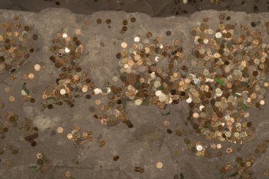 Balkanlar 'daki eski bir kaya manastırının zeminine saçılmış madeni paralar. Geleneksel hacı bağışları.