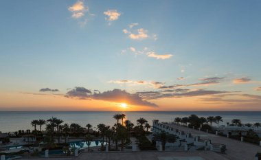 Deniz kıyısında gün doğumu. Güneşin hareketi ve bulutlar gökyüzünde. Mısır 'ın park dinlenme alanları. Bahçe ve manzara tasarımı.