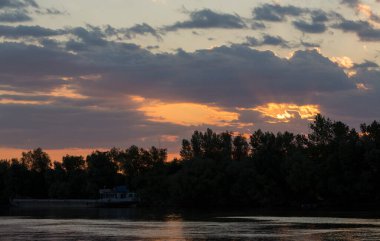Tuna Nehri 'nde kanlı bir günbatımı. Sudaki manzaranın yansıması..