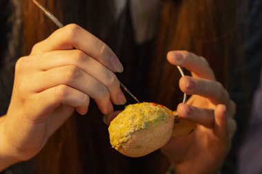 Kız bir zanaat yapıyor ve kağıt hamuru tekniği kullanıyor. Genç sanatçıların yaratıcı süreci.
