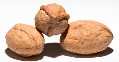 Beyaz arka planda üç ceviz. Kabuk üç lobdan oluşur..