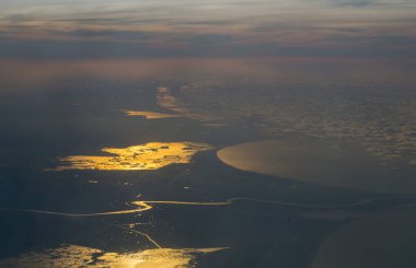 Afrika kıtasının kıyı şeridi. Akdeniz üzerinde gün batımının kuş bakışı görüntüsü. Hava fotoğrafçılığı. Uçak penceresinden görüntüle.