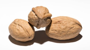 Beyaz arka planda üç ceviz. Kabuk üç lobdan oluşur..