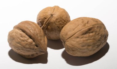 Beyaz arka planda üç ceviz. Kabuk üç lobdan oluşur..