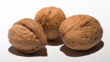 Beyaz arka planda üç ceviz. Kabuk üç lobdan oluşur..