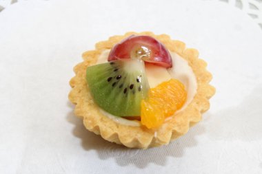 Krem peynirli, kivi, üzüm ve portakalla süslenmiş sağlıklı meyveli tatlı tabağı.