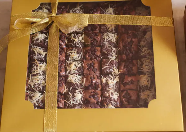 Homemade bronis cake with chocolate flavor and chocolate topping on top, and placed in a cake box