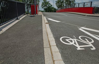 Üzerinde işaretler olan asfalt bisiklet yolu ve güvenli sokak trafiğini imzalayın.