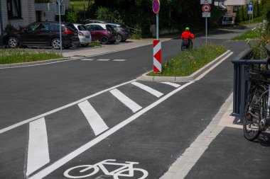Üzerinde işaretler olan asfalt bisiklet yolu ve güvenli sokak trafiğini imzalayın.