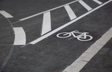 Üzerinde işaretler olan asfalt bisiklet yolu ve güvenli sokak trafiğini imzalayın.