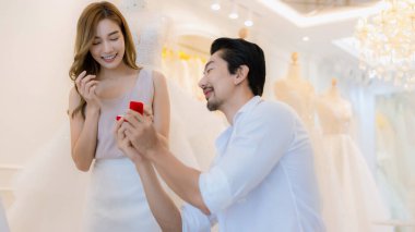 Benimle evlenir misin konsept? Genç kız mutlu ve şaşırmış. Adam güzel kızına nişan yüzüğü verirken evlenme teklif ediyor.