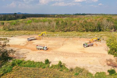 İnşaat alanındaki kazıcının hava görüntüsü. Bir inşaat sahasında hava aracı fotoğrafı. Ağır ekipmanlar toprağı derecelendiriyor.