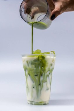 Plastik bardakta Tayland usulü soğuk içecek. El malzemesi buz kabına dökülüyor..