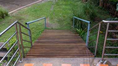 Binanın önünde engelli yolu var. Engelli trafik sembolü, destek tekerlekli sandalyesi için rampanın önünde. Yeşil doğa manzarasında kafenin önünde engelli bir yol.