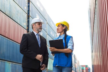 İş adamı ve sekreteri konteyner kargo alanında çalışıyor. Konteynırdaki malları kontrol ediyorlar. Menajer ve müşteri konteynırları kontrol ediyor. Lojistik ve nakliye.