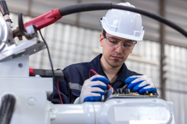 Engineer or Worker in intelligent factory industrial. Engineer check and control automation robot arms machine in intelligent factory industrial
